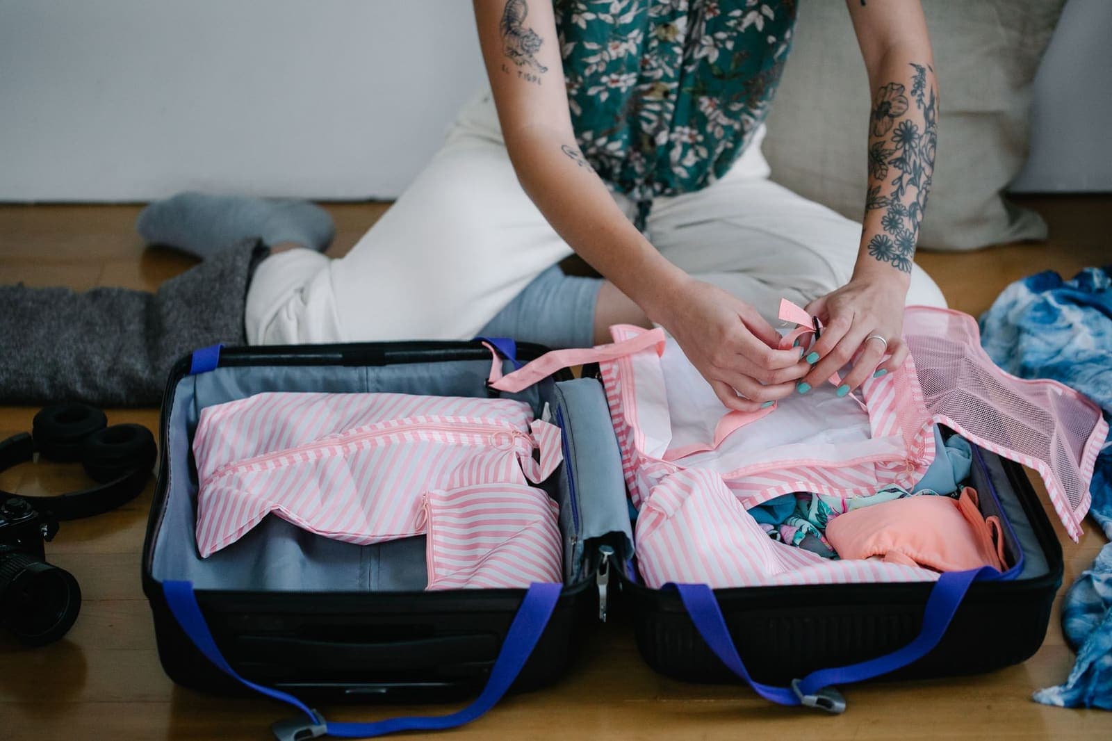 Kleding wordt ingepakt in een open koffer op de vloer