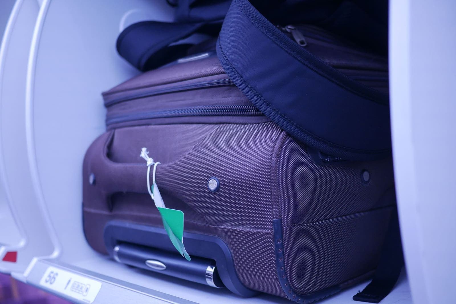 Handbagagekoffer in het bagagevak boven de stoelen in een vliegtuig